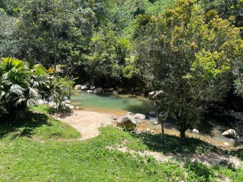a stream of water with trees and grass at Hostal El Silencio Vivo in San Rafael