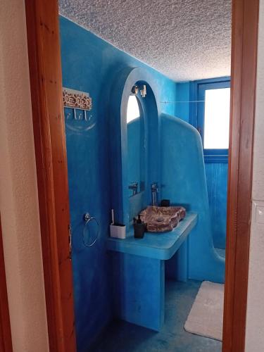 a blue bathroom with a sink and a mirror at Villa marina in Ermioni