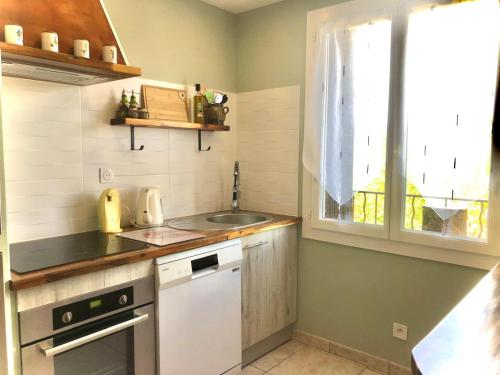 une petite cuisine avec un évier et une fenêtre dans l'établissement Très bel appartement proche des Gorges du Verdon, à Régusse