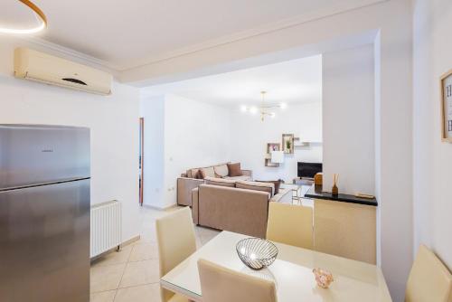 a kitchen and living room with a table and chairs at Kallikratia Suites 2 in Nea Kalikratia