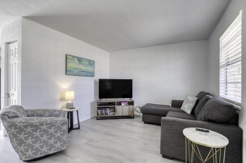 a living room with a couch and a tv at Coquina Cabana with fenced yard and adorable decor in South Daytona
