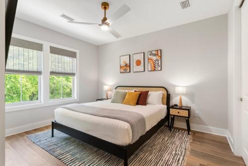 a bedroom with a large bed and two windows at 3Zs Beach House 30A Sleeps 10! in Inlet Beach