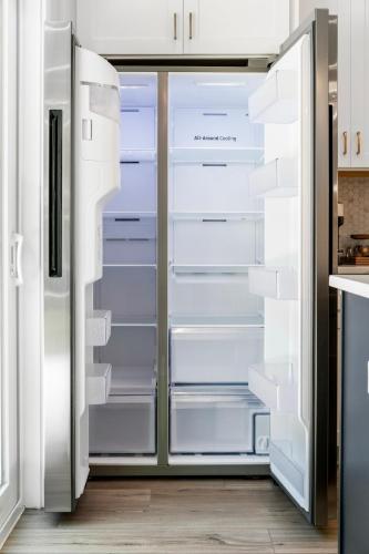 an empty refrigerator with its doors open in a kitchen at 3Zs Beach House 30A Sleeps 10! in Inlet Beach