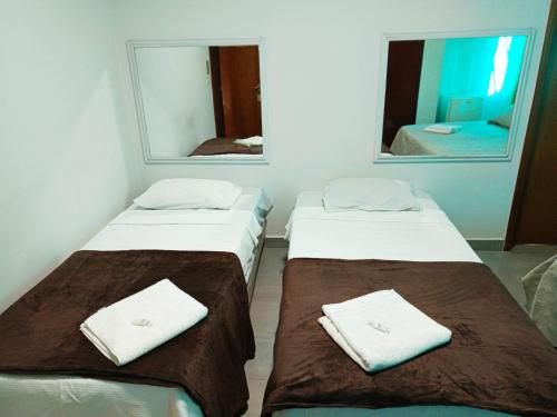 two beds in a room with two mirrors at PEDRA BONITA PRECIOSO HOTEL ltda in Itaboraí