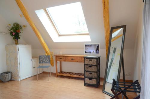 a room with a desk and a mirror and a skylight at Chambre d'hôtes au Domaine de la Moretie in Cublac