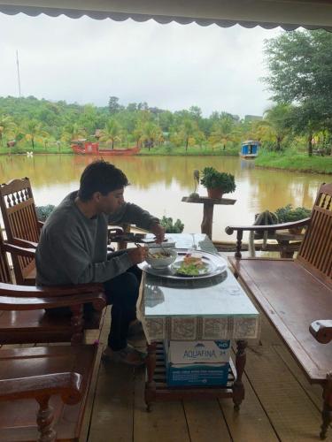 a man sitting at a table with a plate of food at Suối Xanh Garden in Gia Nghĩa