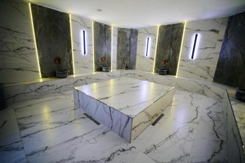 a marble room with a table and three windows at Flora Handüzü Resort & Wellness Bungalow Hotel in Rize