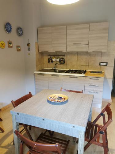 a kitchen with a table with chairs and a sink at Dimora La Fenice in Licola