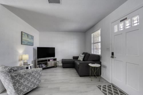 a living room with a couch and a tv at Coquina Cabana with fenced yard and adorable decor in South Daytona
