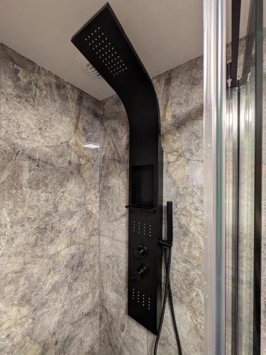 La salle de bains est pourvue d'une douche et d'un mur en pierre. dans l'établissement Les 3 Zepp, à Turckheim