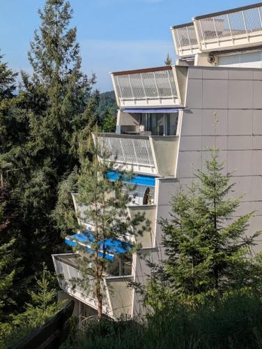 un bâtiment avec des parasols bleus sur son côté dans l'établissement Les 3 Zepp, à Turckheim