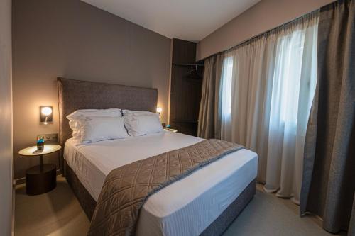 Postel nebo postele na pokoji v ubytování Acropoleos Suites
