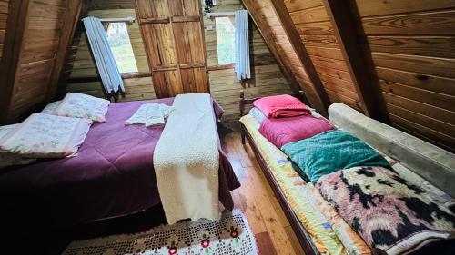 a bedroom with two beds in a log cabin at Chalé Xodó da Serra Urubici in Urubici