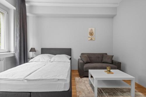 a bedroom with a bed and a couch and a table at Domloge Lofts & Apartments in Cologne