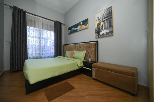 Un dormitorio con una cama y un sofá. en Cascade Cove Kampala -Jacuzzi - Gazebo with Fountain, en Kampala