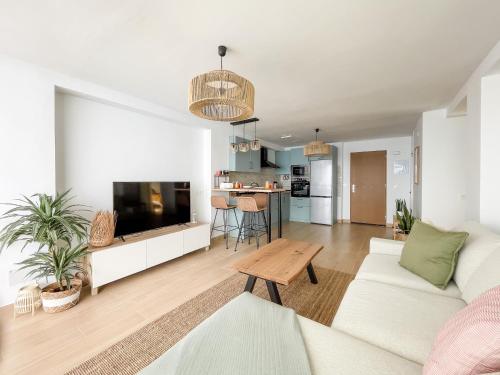 a living room with a white couch and a tv at Ocean views from every corner in Almería