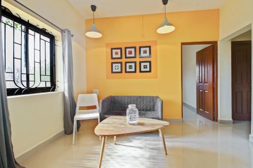 a living room with a couch and a table at Hotel O Spacious Holiday Home in Goa