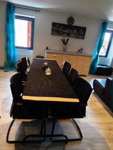 d'une salle à manger avec une table et des chaises dans le salon. dans l'établissement Duplex centre village et proche commodités, à Champagne-en-Valromey
