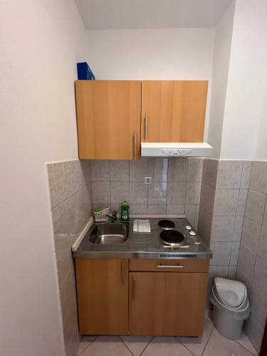 a small kitchen with a sink and a stove at Economy room with kitchenette in Grebaštica