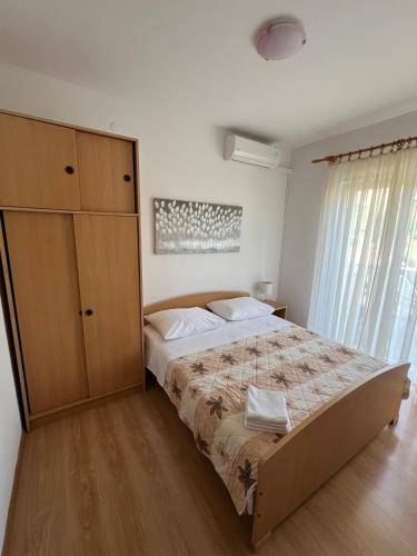 a bedroom with a large bed and a dresser at Economy room with kitchenette in Grebaštica