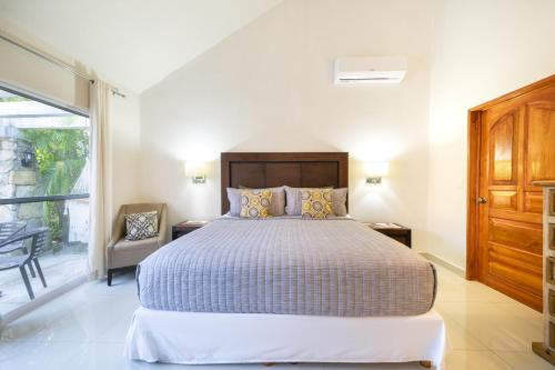 a bedroom with a large bed and a window at Luxury Villa 4BR with Private Pool - At Playacar ll - Villa Perla 15 in Playa del Carmen