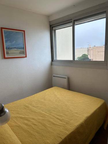 une chambre avec un lit et une fenêtre dans l'établissement T2 Les pieds dans l'eau, accès direct plage, à Valras-Plage