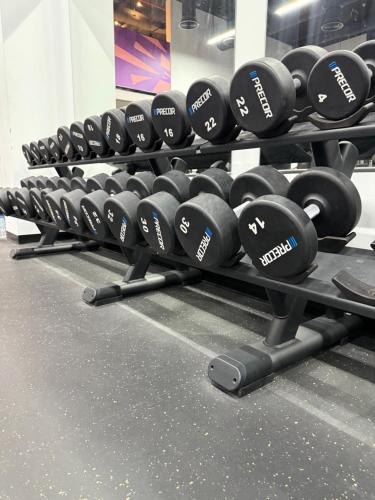 a row of dumbbells on display in a gym at 1 BR Luxury Apt by AJ Aljada in Sharjah