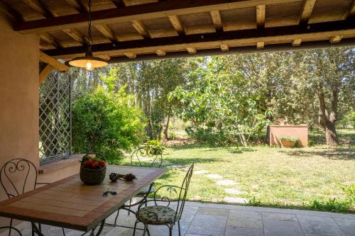 a wooden table and chairs on a patio at Agriturismo Tra gli Ulivi, Chiappini Winery in Bolgheri