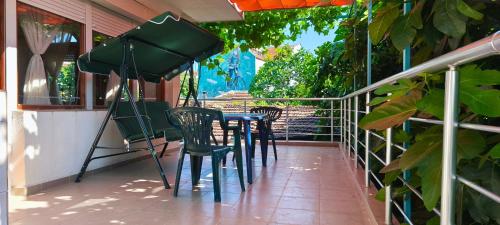 a table and chairs on a porch with a camera at Summerbreath Apartments in Ahtopol