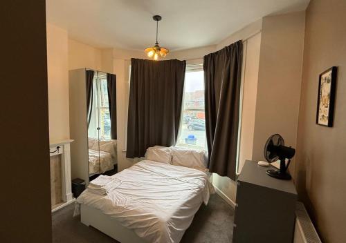 una piccola camera da letto con un letto e una finestra di Peeams Abode Erith a Erith
