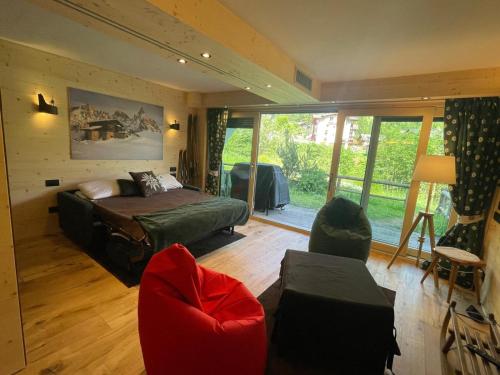 a bedroom with a bed and a couch and chairs at Stella Alpina San Martino di Castrozza vista Pale in San Martino di Castrozza