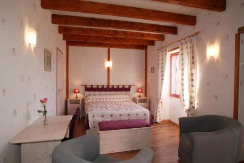 une chambre avec un lit, une table et des chaises dans l'établissement Gîte Au Bonheur des Hôtes en Auvergne, à Égliseneuve-près-Billom