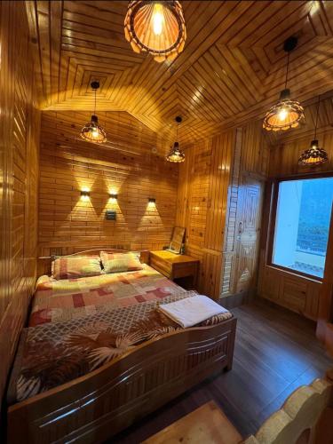 a bedroom with a bed in a wooden room at The Wooden Homestay in Almora