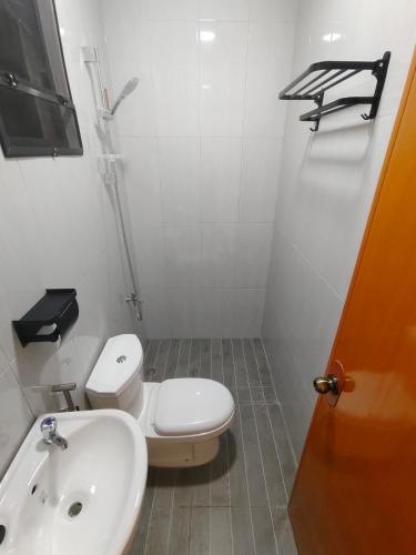 a bathroom with a white toilet and a sink at Papong Guest House in Puerto Princesa City