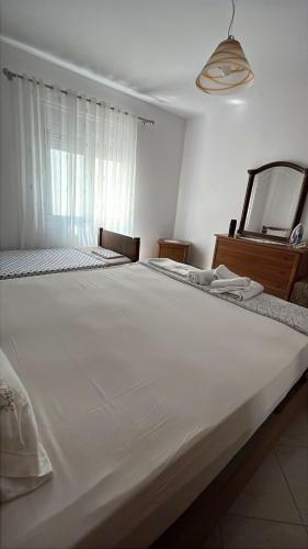 a large white bed in a room with a mirror at Ylli&Njeza Houses in Vlorë