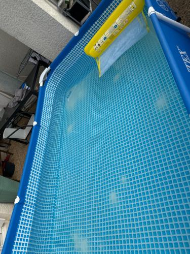 une piscine bleue avec un objet jaune dessus dans l'établissement Belle appartement calme proche aéroport 80m2, à Vitrolles