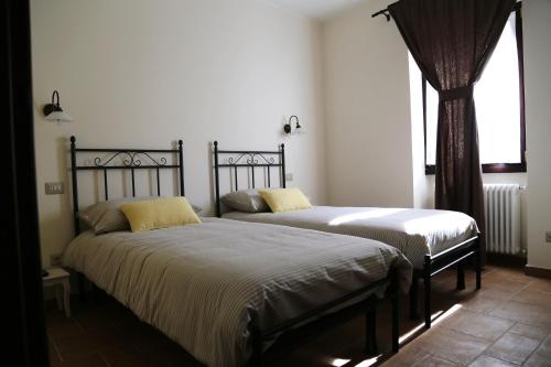 two beds sitting next to each other in a bedroom at Agriturismo Dai Marchesin in Nasino