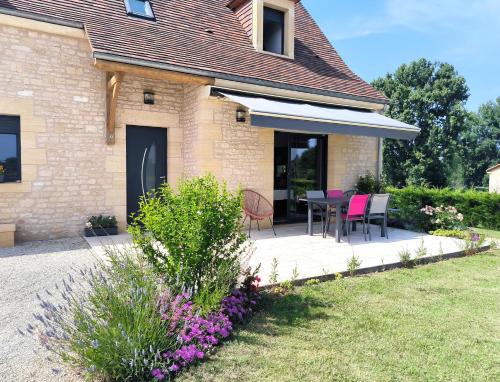 a house with a patio with a table and chairs at Villa Poujol en Dordogne, piscine chauffée in Saint-Crépin-et-Carlucet