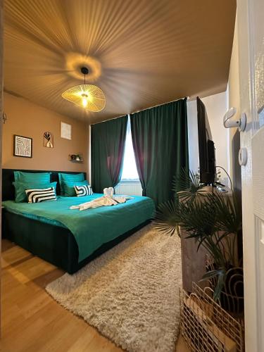 a bedroom with a green bed and a television at Zara’s Home Apartaments in Petroşani