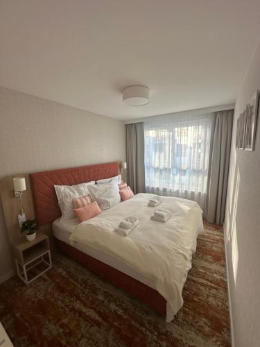 a bedroom with a large bed and a window at Belmare Bursztynowy Zakątek in Międzyzdroje