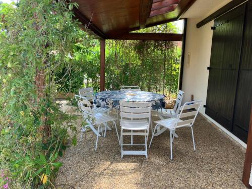 une table et des chaises assises sur une terrasse dans l'établissement Holiday house Les Lauriers-roses 6 persons, 1 km from the beach, à Vendres