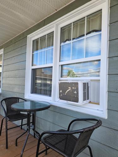 a patio with two chairs and a table and a window at Motel de l'Outlet in Magog-Orford
