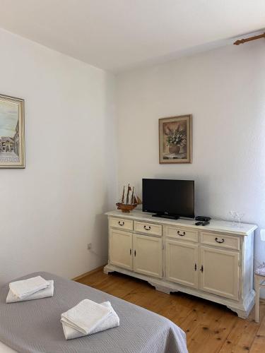 a bedroom with a tv on a white dresser at Apartment Simi in Postira