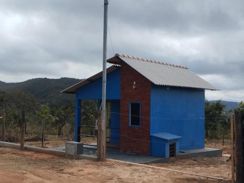a blue and red building with a pole at Chalé da Pousada Avalon Célia in Alto Paraíso de Goiás