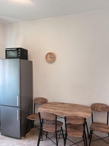 a kitchen with a table with chairs and a refrigerator at Apartment Simi in Postira
