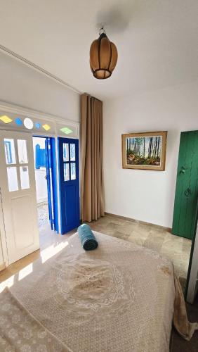 a bedroom with a bed and a blue door at Bleu Azur - Sidi Bou Saïd in Sidi Bou Saïd
