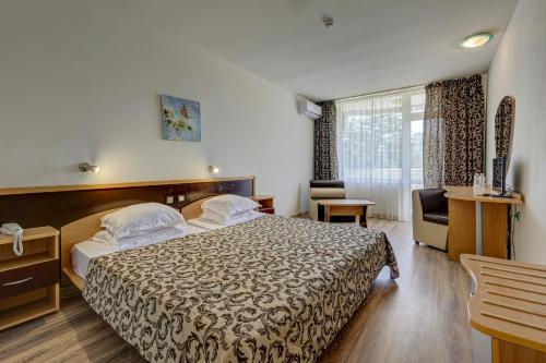 a hotel room with a bed and a chair at Hotel Shipka All Inclusive in Golden Sands