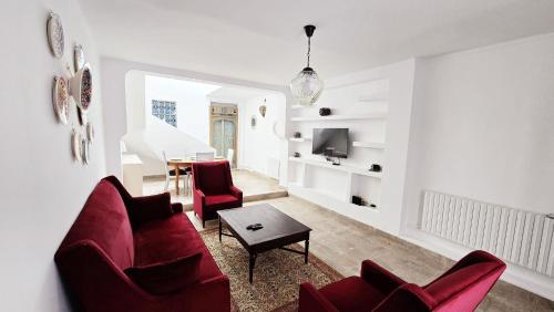 a living room with red chairs and a table at Bleu Azur - Sidi Bou Saïd in Sidi Bou Saïd