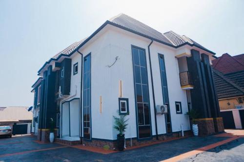 a white building with blue windows on a street at Hotel AREX in Iyiba