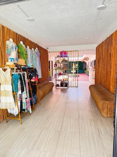 a living room with couches and a room with clothes at Hotel Casa Caracol in Isla Mujeres
